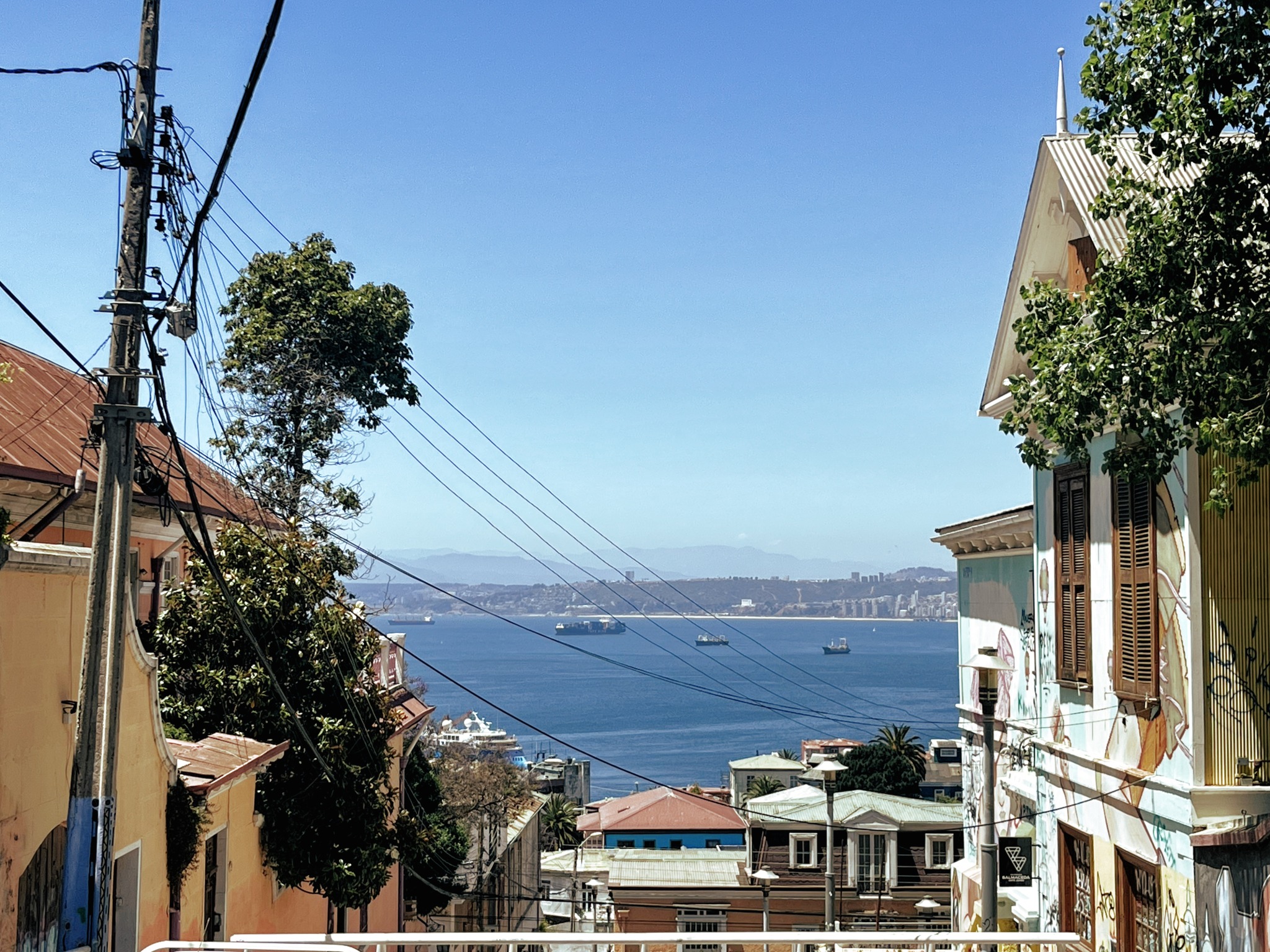 A vista do oceano pacífico entre as casas em uma escadaria de Valparaíso